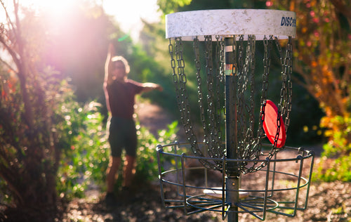 Disc golfer in action at the Disc Golf Pro Tour, throwing a forehand drive with confidence and grip enhanced by Rhino Skin Solutions athlete skincare products.