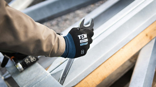 Tradesperson's gloved hands working with a wrench — Rhino skin care for working hands.