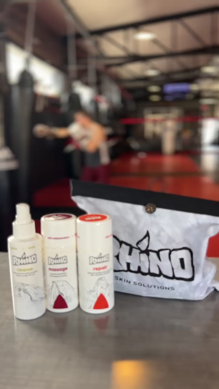 Rhino Skin Solutions Boss Pack displayed with all included products — Cleanse, Massage Cream, Repair Cream, Thick Athletic Tape, Finger Massage Ring, and Mint Wash — arranged neatly in a performance kit. Sponsored by MMA athlete Chey Bowers, highlighting durability