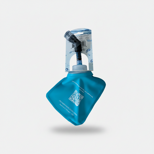 A teal blue collapsible water bottle pouch with a black and clear drinking tube attached, shown with its retail cardboard hanger on a plain white background.