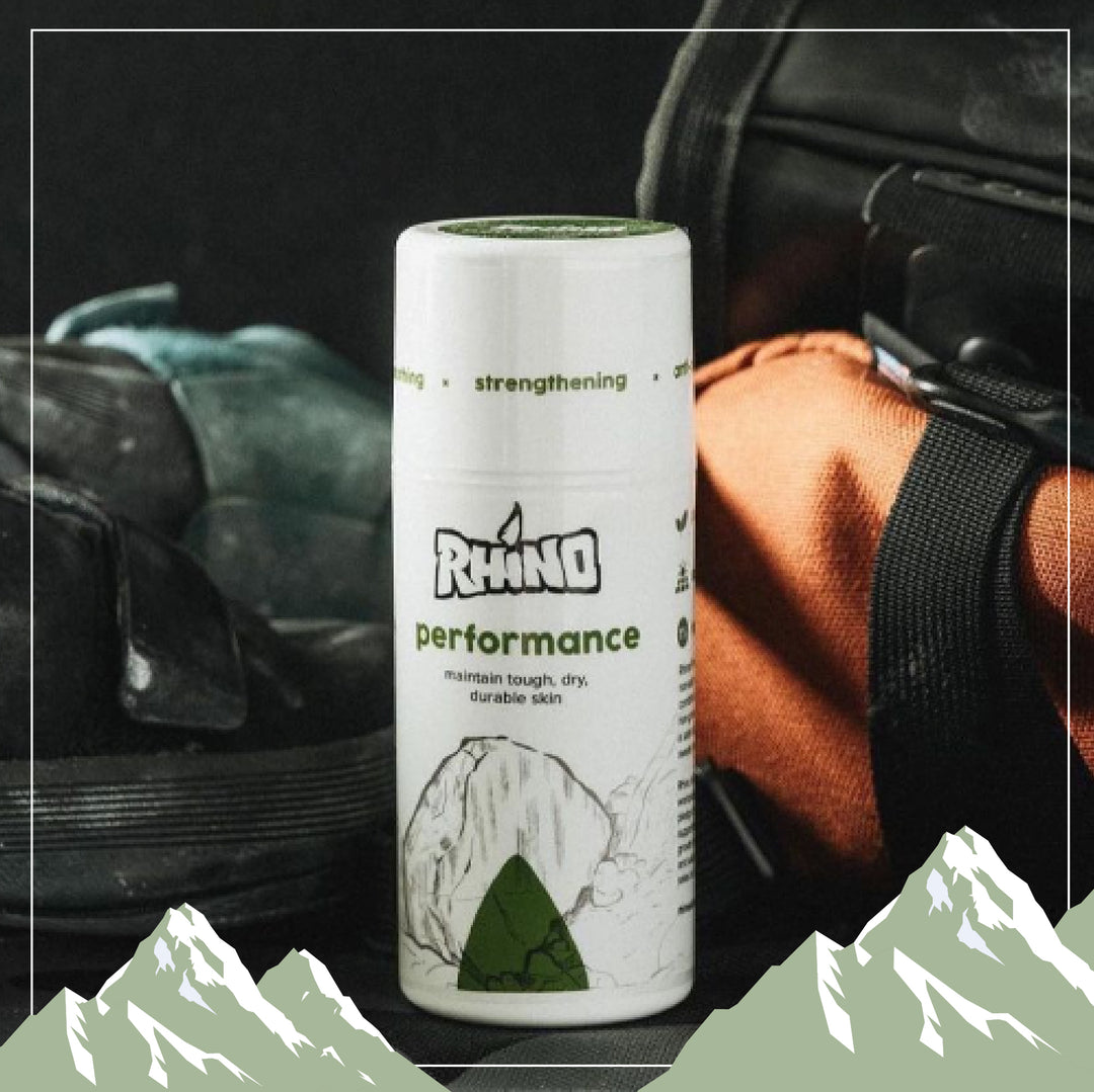 Flat lay of Rhino Skin Solutions full product line including Performance, Repair, Massage, Spit, and Wash—skin care essentials for climbers, athletes, and active individuals. Text reads “Reach New Heights.”