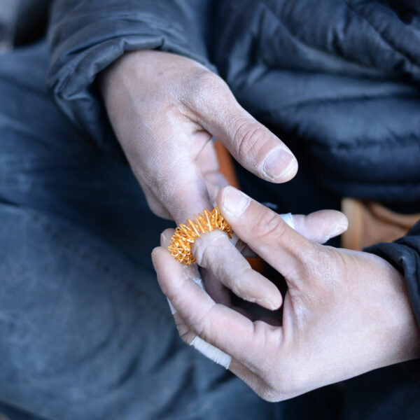 A finger massage ring being gently rolled up and down a person's finger, providing soothing pressure and stimulation to relieve tension and improve circulation.