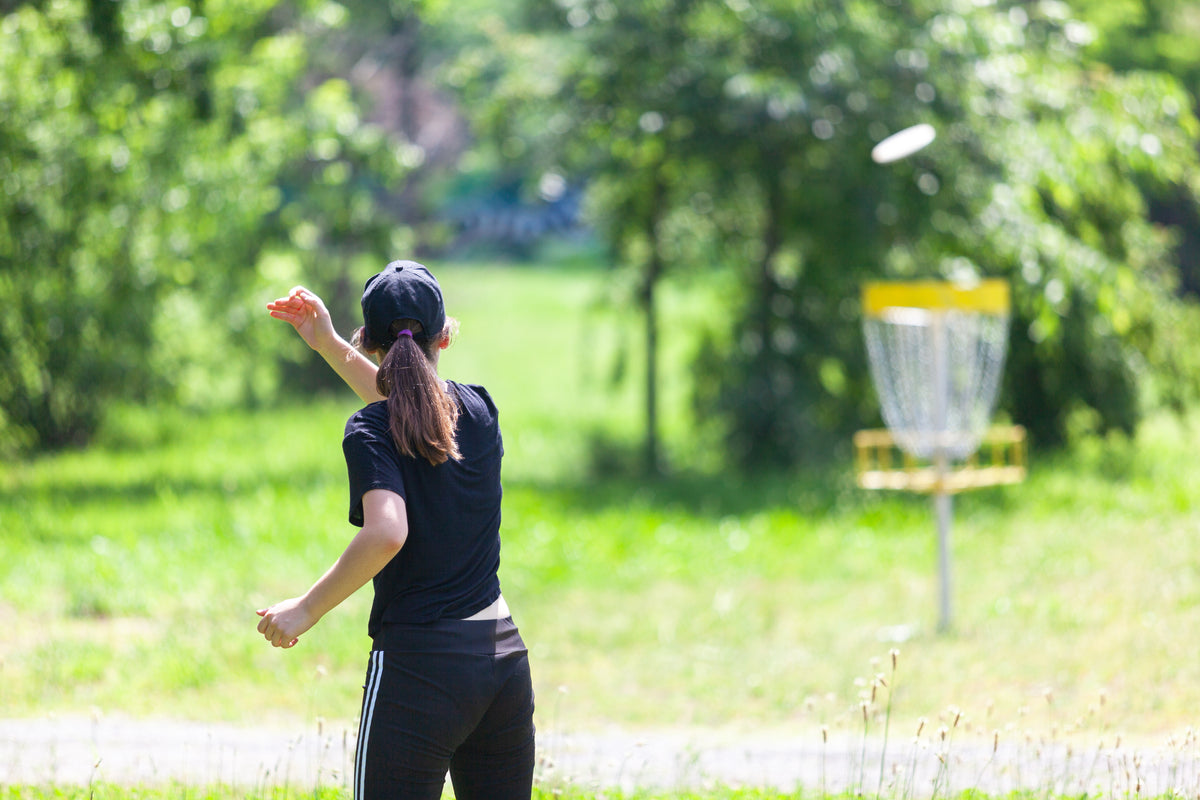 Disc golfer throwing a drive — Rhino skin care for disc golf.
