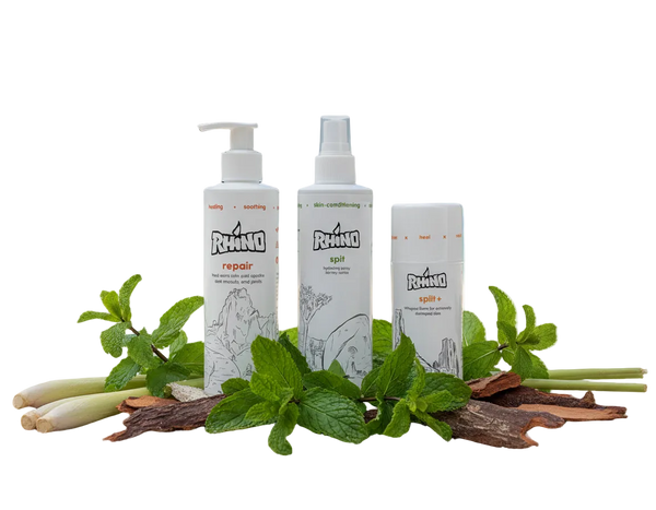 Three Rhino skincare products on a beach with greenery and water in the background