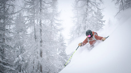 Skier carving through fresh snow — Rhino skin care protects hands in cold, dry conditions.